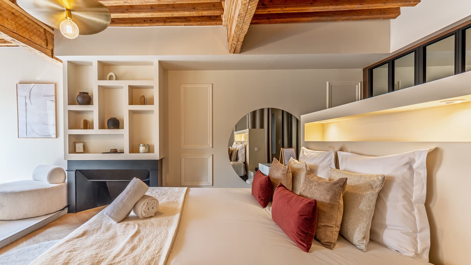 Chambre avec miroir rond, cheminée et niches décoratives, Pure Haven