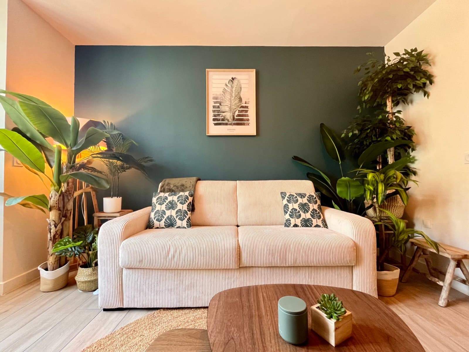 Salon cosy avec canapé beige, mur bleu canard et plantes tropicales, Jungle Haven